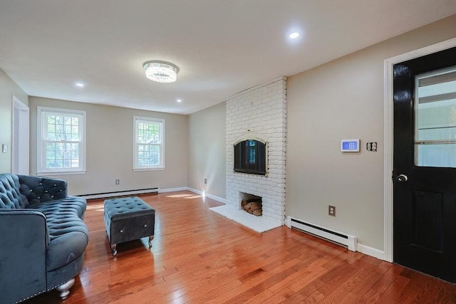 living area with baseboard heating, light wood-style flooring, a fireplace, baseboards, and recessed lighting