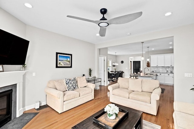 54 Sunflower Way, Plymouth, MA 02360 - living room featuring light wood-type flooring, a fireplace with flush hearth, recessed lighting, ceiling fan, and baseboards