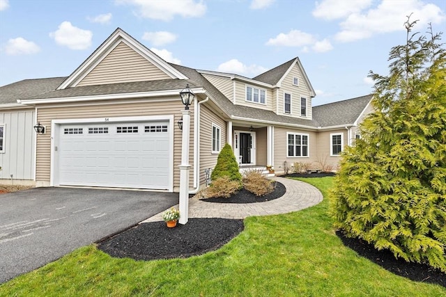 54 Sunflower Way, Plymouth, MA 02360 - traditional home with a garage, asphalt driveway, a front lawn, board and batten siding, and roof with shingles