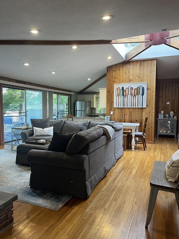 233 Hoopdole Rd, Mashpee, MA 02649 - living area with lofted ceiling, light wood-type flooring, and wooden walls