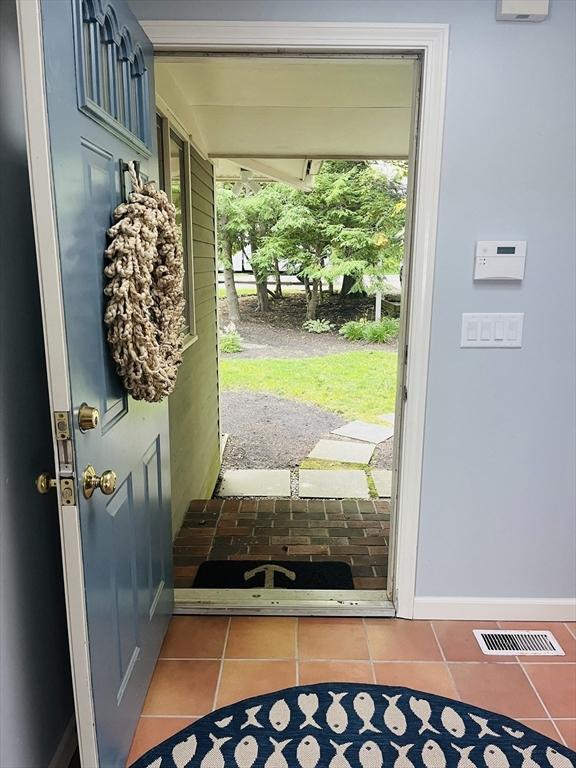 233 Hoopdole Rd, Mashpee, MA 02649 - doorway to outside featuring tile patterned floors and baseboards