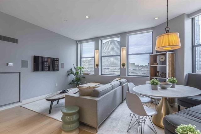 living area featuring light wood finished floors, baseboards, visible vents, and recessed lighting