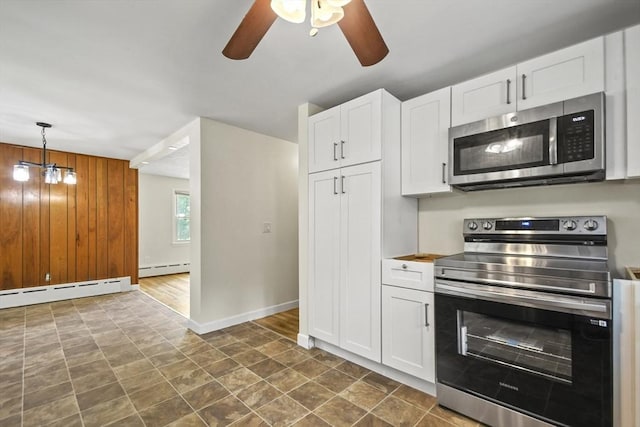 35 Woodland Rd, Leominster, MA 01453 - kitchen featuring appliances with stainless steel finishes, a baseboard radiator, ceiling fan, white cabinets, and wooden walls