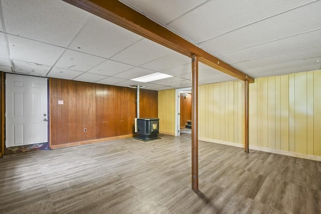 35 Woodland Rd, Leominster, MA 01453 - finished below grade area featuring a wood stove, wood finished floors, wood walls, and a paneled ceiling