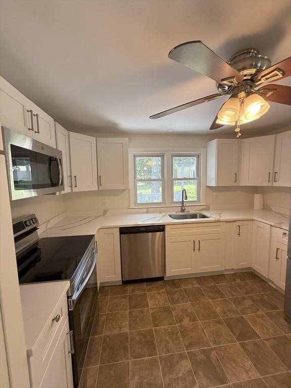 35 Woodland Rd, Leominster, MA 01453 - kitchen with appliances with stainless steel finishes, white cabinets, light countertops, and ceiling fan