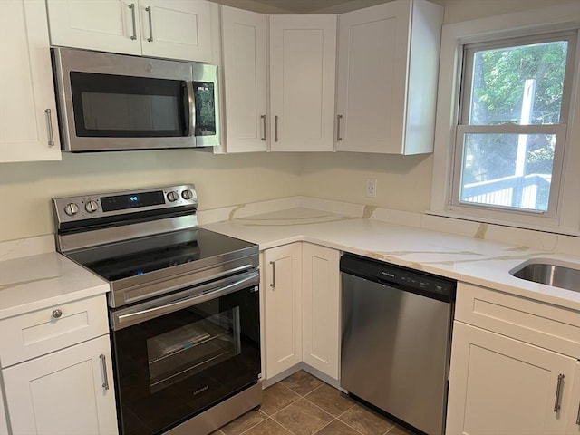 35 Woodland Rd, Leominster, MA 01453 - kitchen with appliances with stainless steel finishes, white cabinets, and dark tile patterned flooring