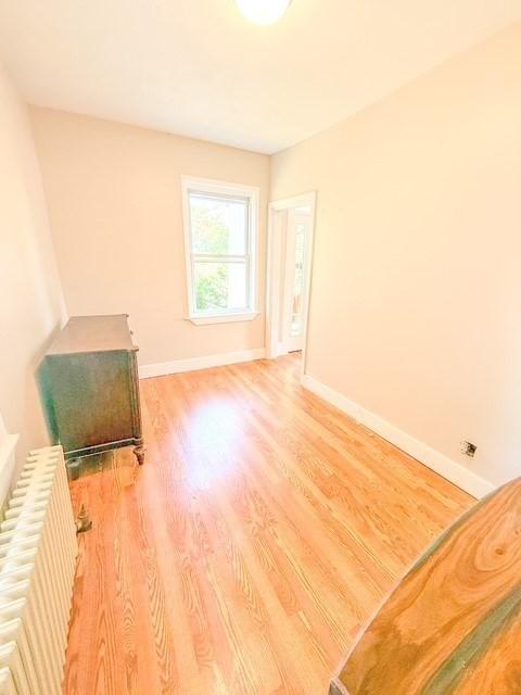 68 Forest St, Lowell, MA 01851 - unfurnished room with radiator heating unit and light wood finished floors