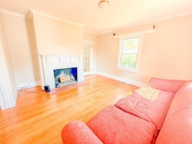 68 Forest St, Lowell, MA 01851 - living area featuring ornamental molding, wood finished floors, and a fireplace with flush hearth