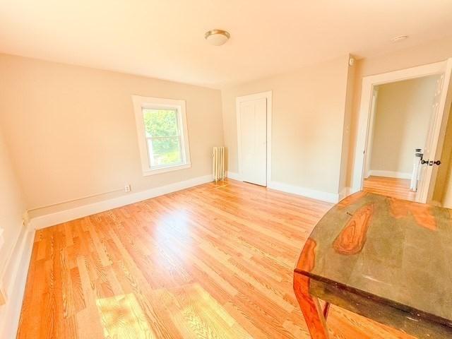 68 Forest St, Lowell, MA 01851 - empty room featuring radiator and wood finished floors