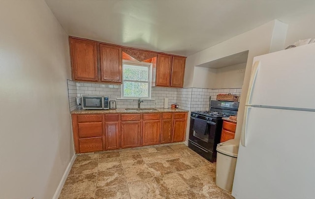 68 Forest St, Lowell, MA 01851 - kitchen featuring freestanding refrigerator, black gas range, stainless steel microwave, and brown cabinetry