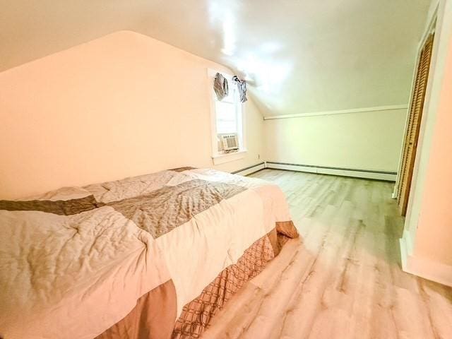 68 Forest St, Lowell, MA 01851 - bedroom with wood finished floors, vaulted ceiling, baseboard heating, and cooling unit