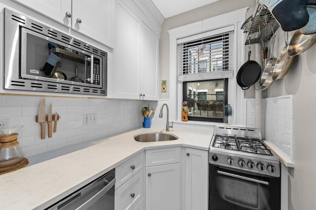 kitchen with sink, white cabinetry, appliances with stainless steel finishes, and tasteful backsplash