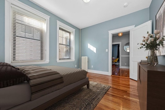 bedroom with wood-type flooring and radiator heating unit