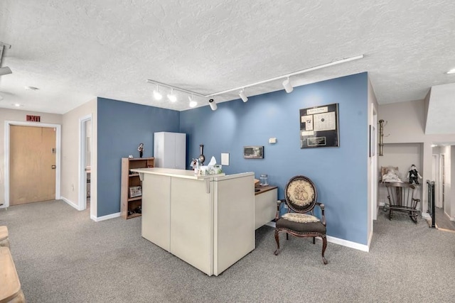 carpeted home office with rail lighting and a textured ceiling