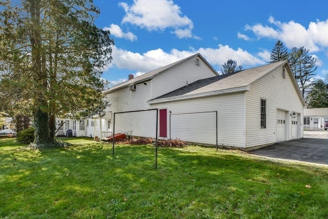 rear view of house featuring a garage and a lawn