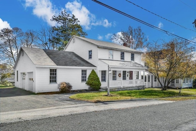 view of front of house with a garage, a porch, and a front yard