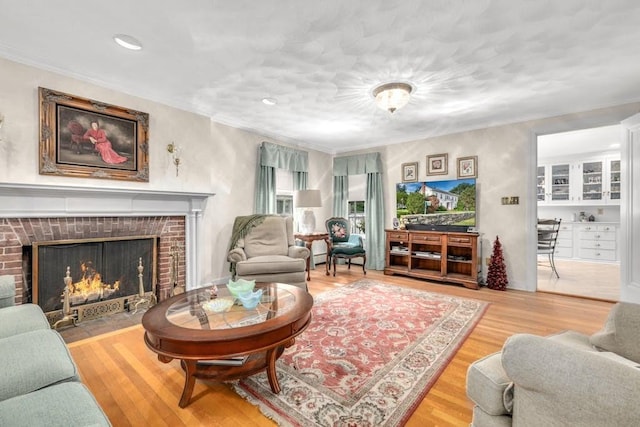 living room with hardwood / wood-style flooring, a fireplace, and crown molding