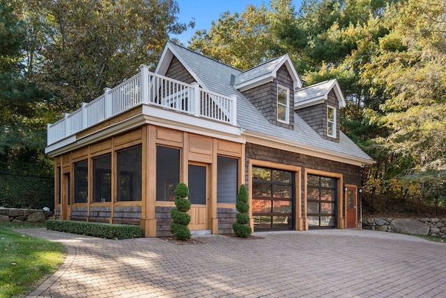 view of front of house with a sunroom, a balcony, and a garage