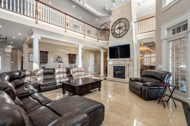 150 Horseneck Rd, Dartmouth, MA 02748 - living area with decorative columns, a high ceiling, a large fireplace, ornamental molding, and baseboards