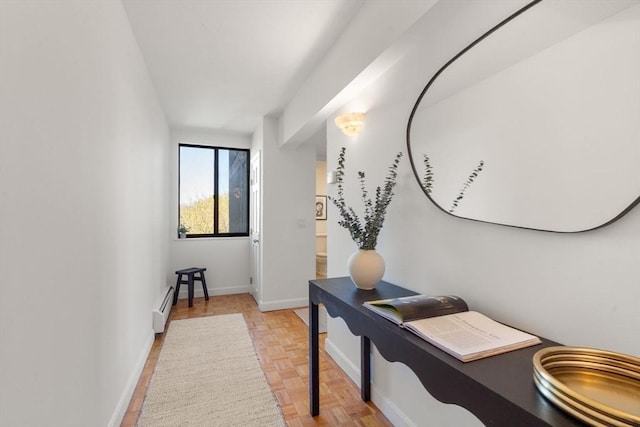 hallway with a baseboard radiator and baseboards