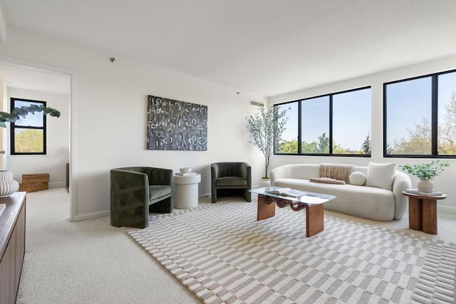 living area featuring light colored carpet and baseboards