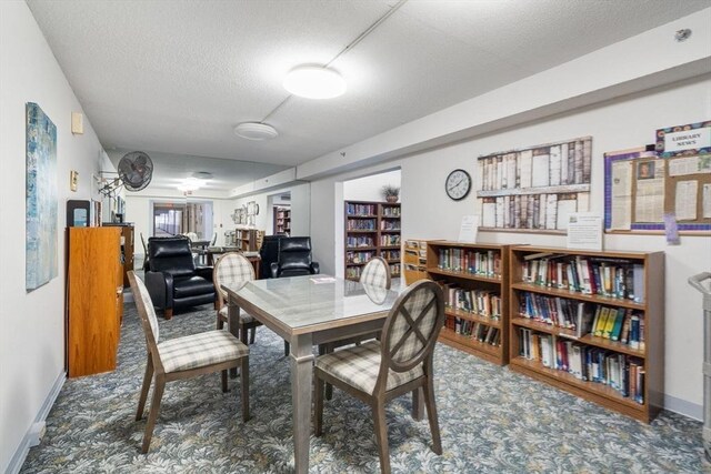dining space with a textured ceiling, baseboards, carpet, and a desk