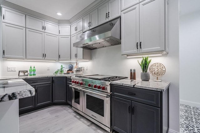 261 E St, Foxboro, MA 02035 - kitchen featuring range with two ovens, under cabinet range hood, light stone countertops, light wood-style flooring, and recessed lighting