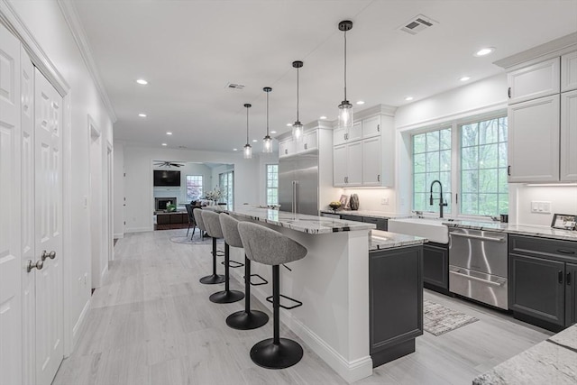 261 E St, Foxboro, MA 02035 - kitchen featuring stainless steel appliances, open floor plan, a kitchen island, light stone countertops, and a breakfast bar area