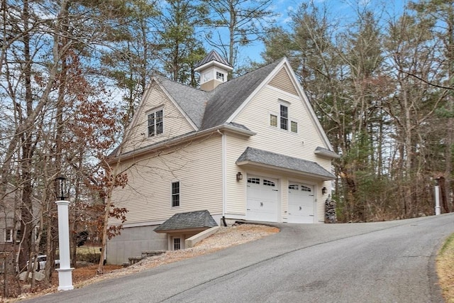 261 E St, Foxboro, MA 02035 - view of property exterior featuring a garage, driveway, and roof with shingles