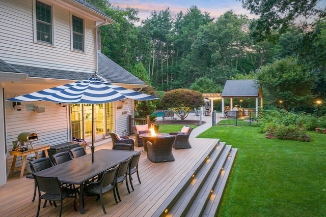 261 E St, Foxboro, MA 02035 - deck at dusk featuring a fire pit, outdoor dining space, and a yard