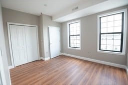 unfurnished bedroom with hardwood / wood-style floors and a closet