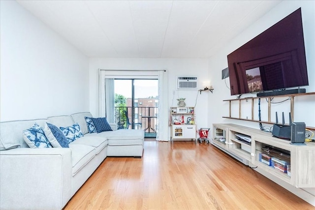 living area featuring an AC wall unit and light wood-type flooring