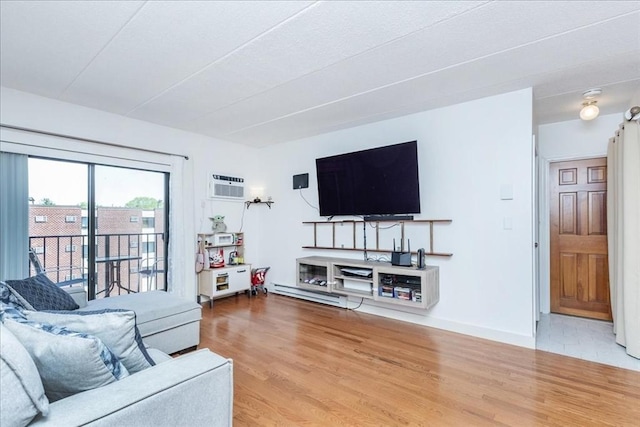 living room with wood finished floors, a wall unit AC, and baseboards