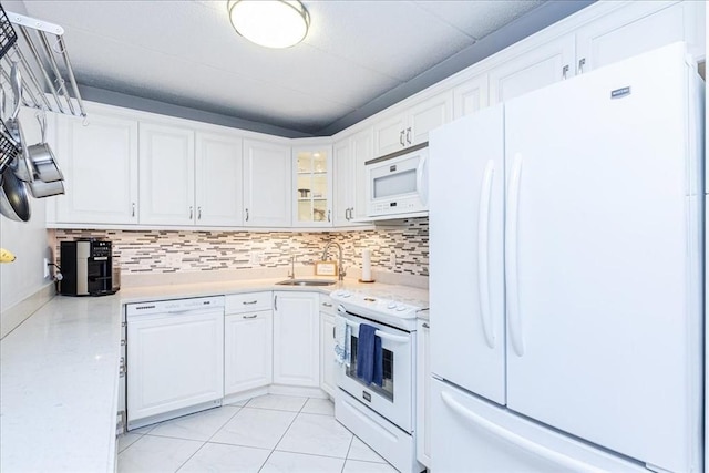 kitchen featuring white appliances, a sink, white cabinetry, and tasteful backsplash