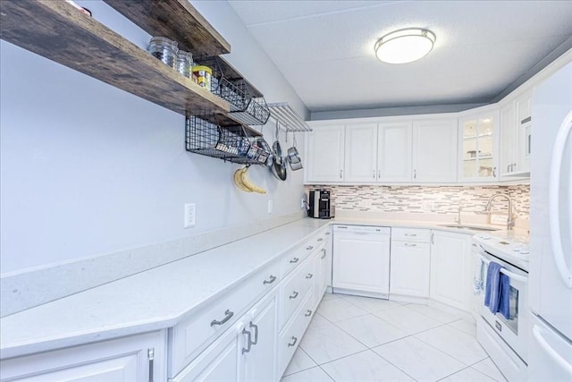 kitchen featuring white appliances, a sink, decorative backsplash, white cabinetry, and light countertops