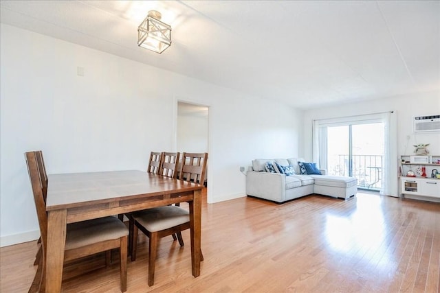 dining room featuring light wood-style flooring and a wall mounted AC