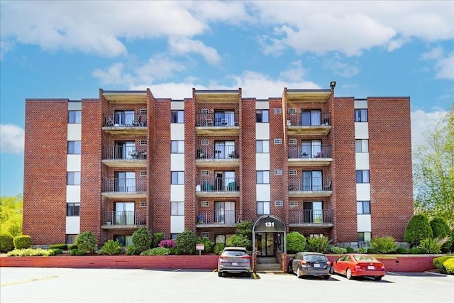 view of apartment building / complex with uncovered parking