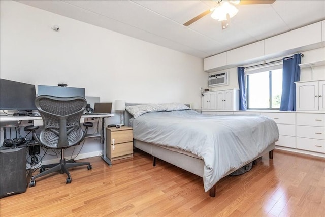 bedroom with light wood-style floors, a wall unit AC, and a ceiling fan