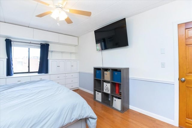 bedroom featuring wood finished floors, baseboards, and ceiling fan