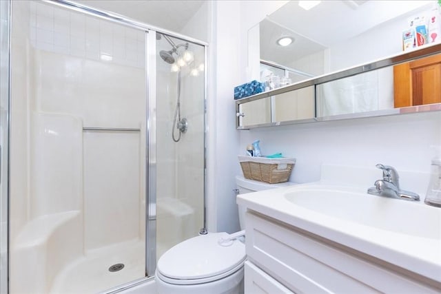 bathroom with a stall shower, toilet, and vanity