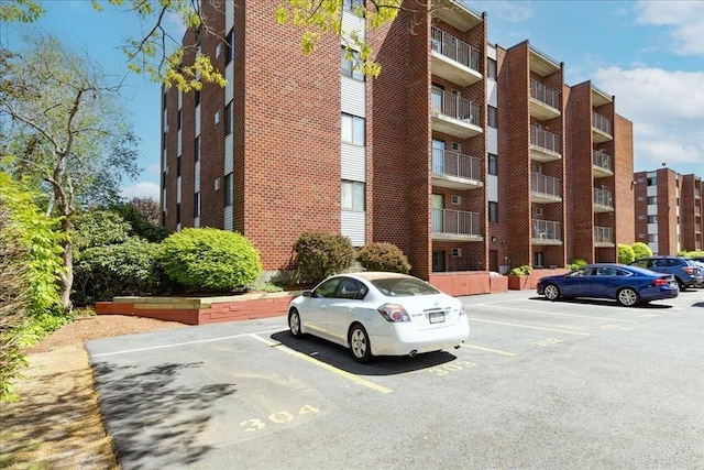 view of apartment building / complex featuring uncovered parking