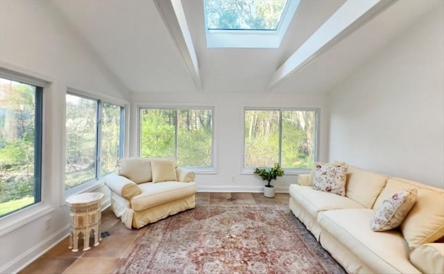 sunroom with baseboards, tile patterned flooring, a wealth of natural light, and lofted ceiling with skylight