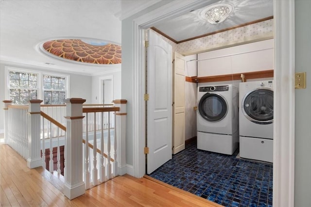 laundry area with crown molding, laundry area, wood-type flooring, and independent washer and dryer
