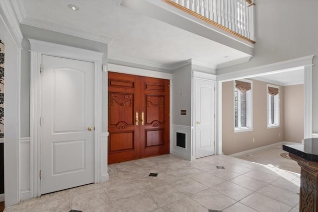 foyer entrance with french doors, ornamental molding, and baseboards