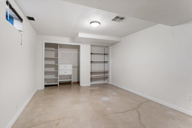 unfurnished bedroom featuring visible vents, baseboards, concrete flooring, and a closet