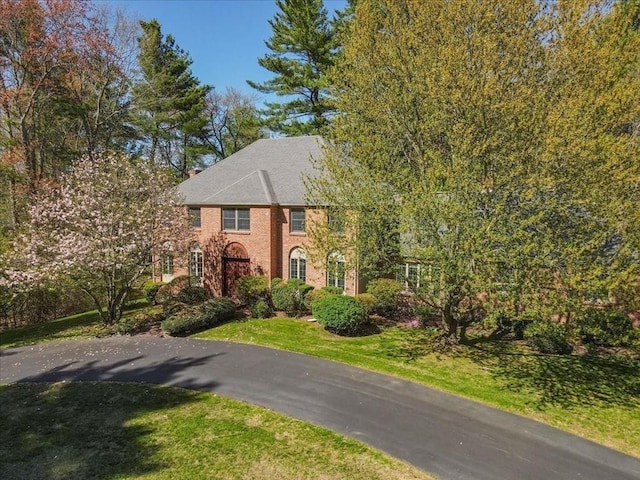 view of front of home featuring brick siding and a front yard