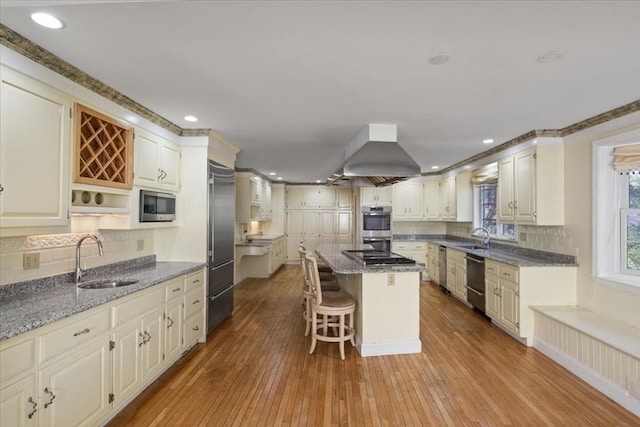 kitchen featuring a center island, a sink, tasteful backsplash, and stainless steel appliances