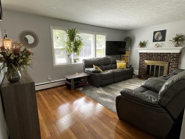 412 Worcester St, West Boylston, MA 01583 - living area with a baseboard radiator, a brick fireplace, wood finished floors, a baseboard heating unit, and a textured ceiling