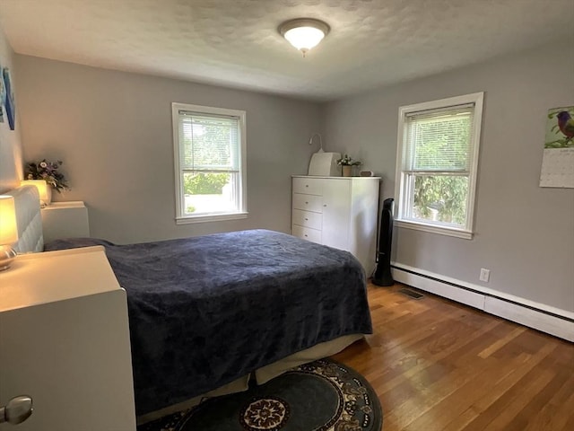 412 Worcester St, West Boylston, MA 01583 - bedroom with multiple windows, wood finished floors, and a baseboard radiator