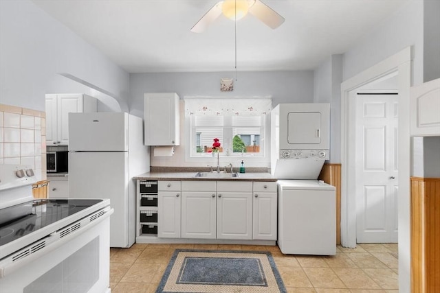 130 Francis St, Everett, MA 02149 - kitchen featuring white appliances, stacked washing machine and dryer, white cabinetry, ceiling fan, and decorative backsplash